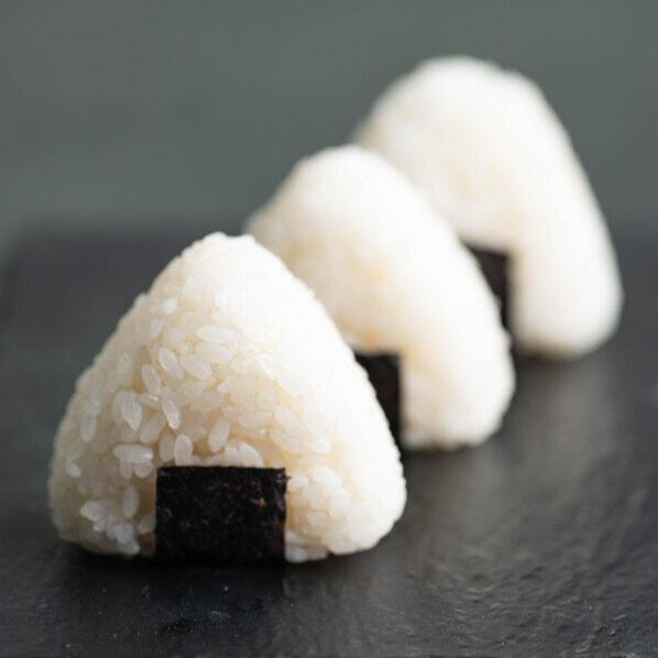 Onigiri A simple Doman dish consisting of hand-shaped balls of lightly salted rice wrapped in dried seaweed.